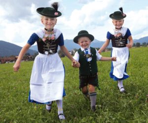 Lachende Kinder laufen über eine Wiese